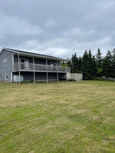 a house with a large yard in front of it at Harbours View in Portuguese Cove