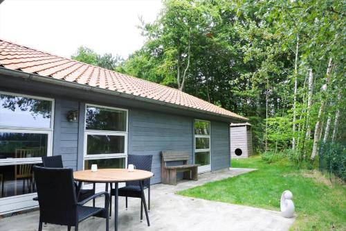 a patio with a table and chairs in front of a house at 11806-Nykobing-Sj-Klintegarden-1 in Klint