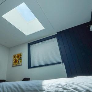 a window in a bedroom with a bed and a windowvisor at 사천잠보호텔 in Sacheon