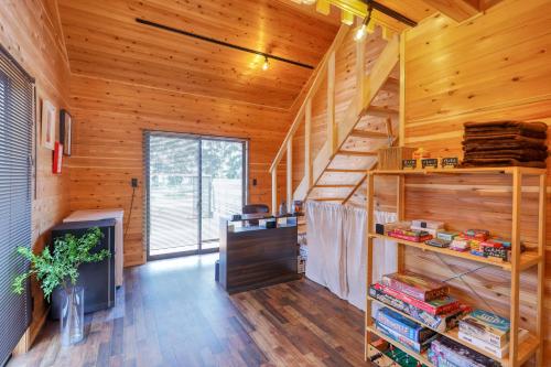a room with wooden walls and a staircase in a cabin at Almin Base 全室プライベートサウナ付きの宿 in Minami Alps