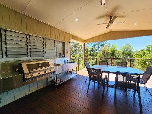 a kitchen with a table and a grill and a dining room at Avoca Holiday House Fraser Island in Kingfisher Bay