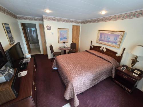 a hotel room with a bed and a television at Lake View Motel in Cooperstown