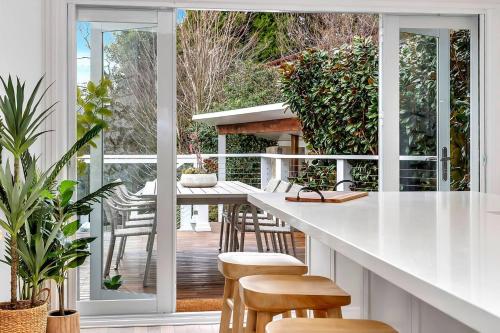 a kitchen with a white counter and chairs at Casa Santorini - Entertainer's Paradise in the Hills in Bridgewater