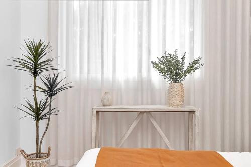 a bedroom with a table with two plants on it at Casa Santorini - Entertainer's Paradise in the Hills in Bridgewater