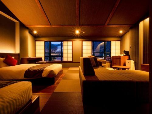 a bedroom with two beds and a living room at Unzen Fukudaya in Unzen