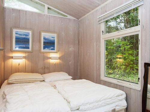 a bedroom with a bed and a window at 8 person holiday home in Rønde-By Traum in Rønde