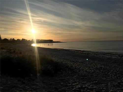 a beach with the sun setting over the water at 11804-Nykobing-Sj-Linesvej-2 in Nyrup