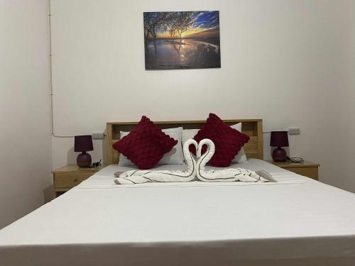a bedroom with a bed with two swans on it at A&C Aquino Guesthouse in Moalboal