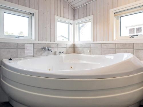a white bath tub in a bathroom with two windows at 8 person holiday home in Frørup-By Traum in Frørup