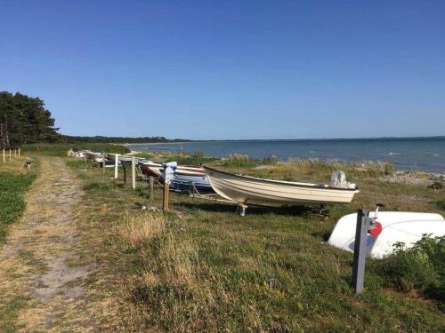 a row of boats sitting on the grass near the water at 12255-Sjaellands-Odde-Klokkelyngvej-5 in Tjørneholm