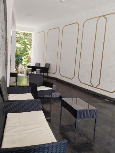 a waiting room with chairs and tables and a wall at Hotel Ventanas Al Paraiso in Agua Buena