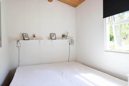 a white room with a bed and a window at 11815-Nykobing-Sj-Birkevaenget-21 in Klint