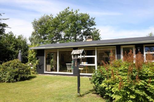a small house with a sign in the yard at 11815-Nykobing-Sj-Birkevaenget-21 in Klint