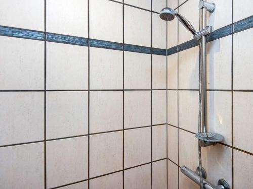 a shower with a blue and white tiled wall at 4 person holiday home in Ansager-By Traum in Ansager