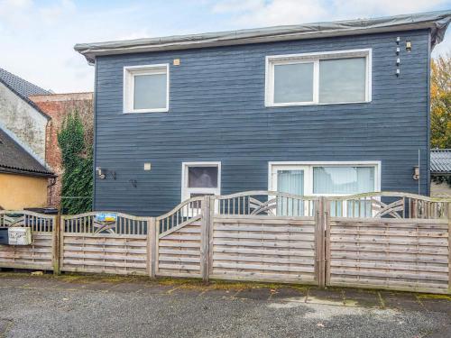 a blue house with a wooden fence in front of it at 4 person holiday home in Ansager-By Traum in Ansager
