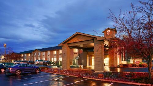a building with a car parked in a parking lot at Best Western Plus Rama Inn & Suites in La Grande