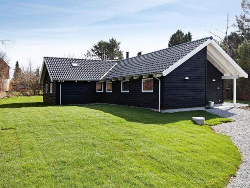 a black house with a large yard in front of it at Luxury Retreat in Hornbaek - By Traum Ferienwohnungen in Hornbæk