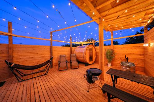 a wooden deck with a hammock and a bench at Almin Base 全室プライベートサウナ付きの宿 in Minami Alps