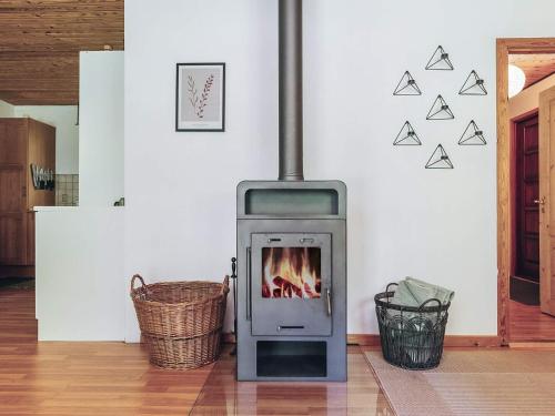 a wood stove in a room with a wall at 4 person holiday home in Læsø in Læsø
