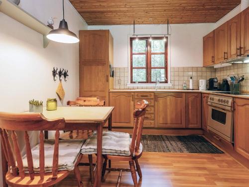 a kitchen with wooden cabinets and a table and chairs at 4 person holiday home in Læsø in Læsø