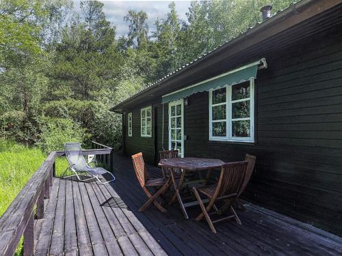 a wooden deck with a table and chairs on a house at 4 person holiday home in Læsø in Læsø