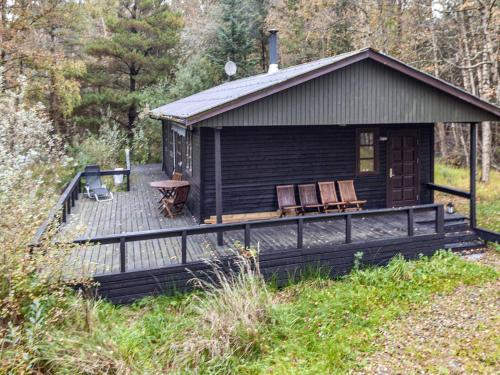 a cabin with a deck with chairs and a table at 4 person holiday home in Læsø in Læsø