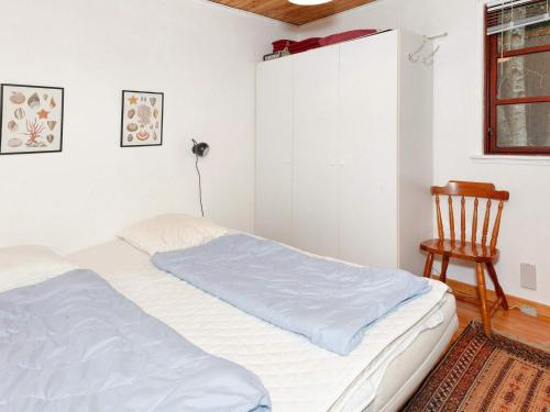 a bedroom with a bed and a wooden chair at 4 person holiday home in Læsø in Læsø