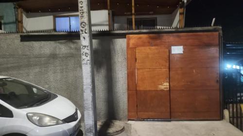 a white car parked in front of a wooden door at casa para empresa o vacaciones in Iquique