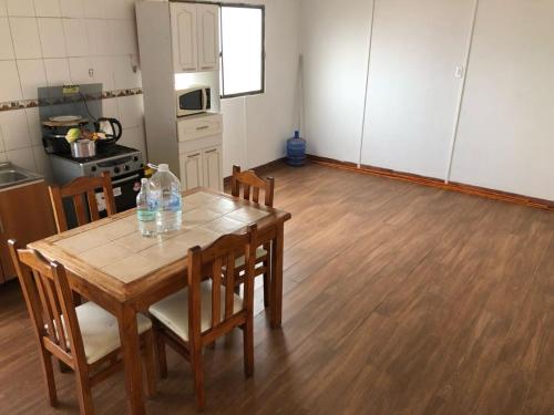 a kitchen with a table with chairs and bottles on it at casa para empresa o vacaciones in Iquique