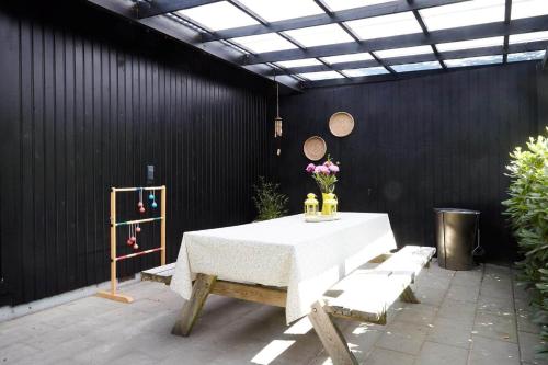a table and chairs in a patio with a black wall at 10000-1-Rorvig-Birkealle-2-A in Rørvig