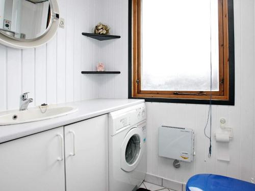a bathroom with a washing machine and a sink at 6 person holiday home in Løkken-By Traum in Løkken