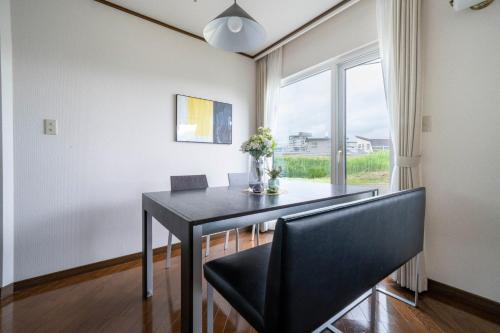 un comedor con una mesa negra y una ventana en Sekka, en Furano