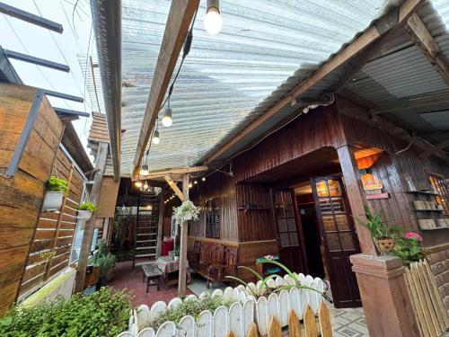 a building with a porch with a fence in front of it at Nhà Ngoại Ô in Ấp Man Ling