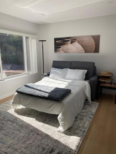 a bedroom with a large bed with a rug at 2 Palo Alto - Fully Furnished with Parking, Laundry, AC, Private in East Palo Alto