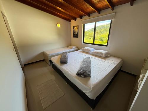a bedroom with two beds and a window at Hotel Selva Cristal in San Carlos