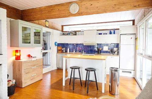 a kitchen with white cabinets and bar stools in it at 11102-1-Nykobing-Sjaelland-Vindingsvej-16 in Nykøbing Sjælland