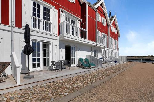 a row of red and white buildings with green chairs at 11203-Nykobing-Sj-Havnevej-63-st-th in Nykøbing Sjælland