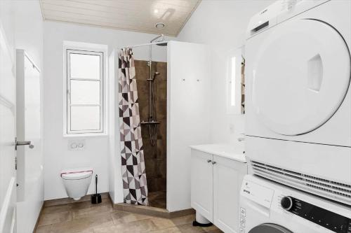 a bathroom with a toilet and a sink and a mirror at 0003-Romo-Vestervej-39 in Toftum