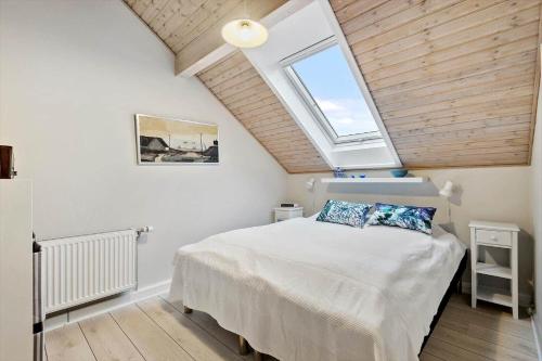 a bedroom with a large bed with a skylight at 0366-Romo-Vestergade-153-B-Ap-126 in Sønderby