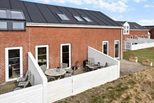 a brick building with a patio with a table and chairs at 0366-Romo-Vestergade-153-B-Ap-126 in Sønderby