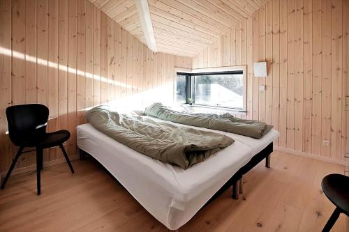 a bed in a room with a window and a chair at 10067-Nykobing-Sj-Niels-Jensens-Vaenge-2 in Rørvig