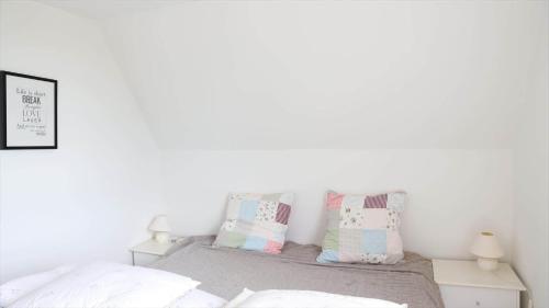a bedroom with white walls and a bed with pillows at 10098-Rorvig-Fjordvaenget-17 in Rørvig