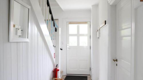 a hallway with a white door and a red fire extinguisher at 10098-Rorvig-Fjordvaenget-17 in Rørvig