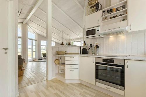 a kitchen with white cabinets and a stove top oven at 8014-Knebel-Rastestedet-16 in Knebel