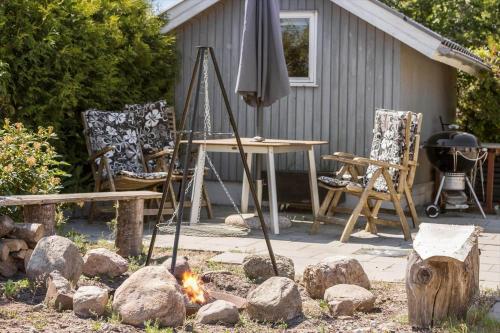 a fire pit with an umbrella and a table and chairs at 8014-Knebel-Rastestedet-16 in Knebel