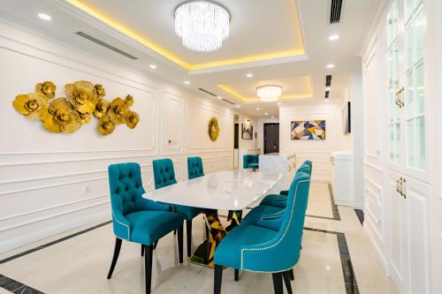 a dining room with a white table and blue chairs at Five Star Westlake 1st-4th Floors Hotel & Serviced Apartment in Hanoi