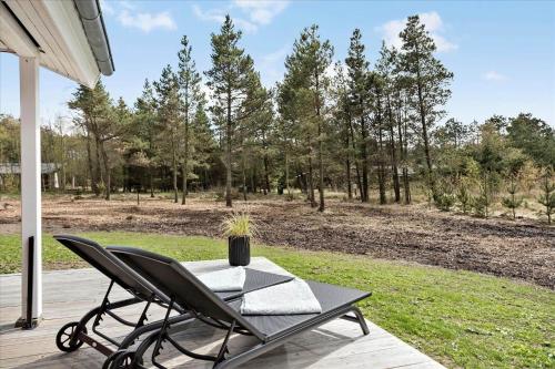 a table and chair on a porch with a field at 0351-Romo-Regnspoven-8 in Mølby
