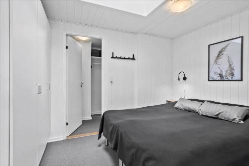 a bedroom with a bed in a white room at 0351-Romo-Regnspoven-8 in Mølby