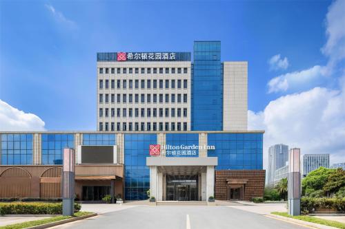 a building with a sign on top of it at Hilton Garden Inn Zhuji East in Shaoxing
