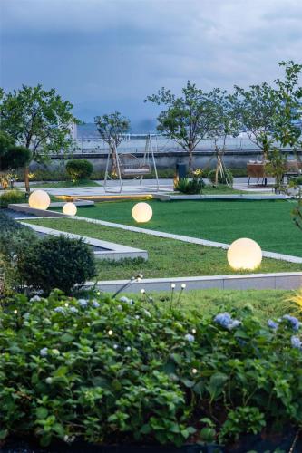 a park with a playground with umbrellas in the grass at Hilton Garden Inn Zhuji East in Shaoxing